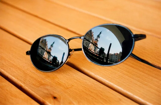 Runde dunkle Sonnenbrille auf einem Holztisch